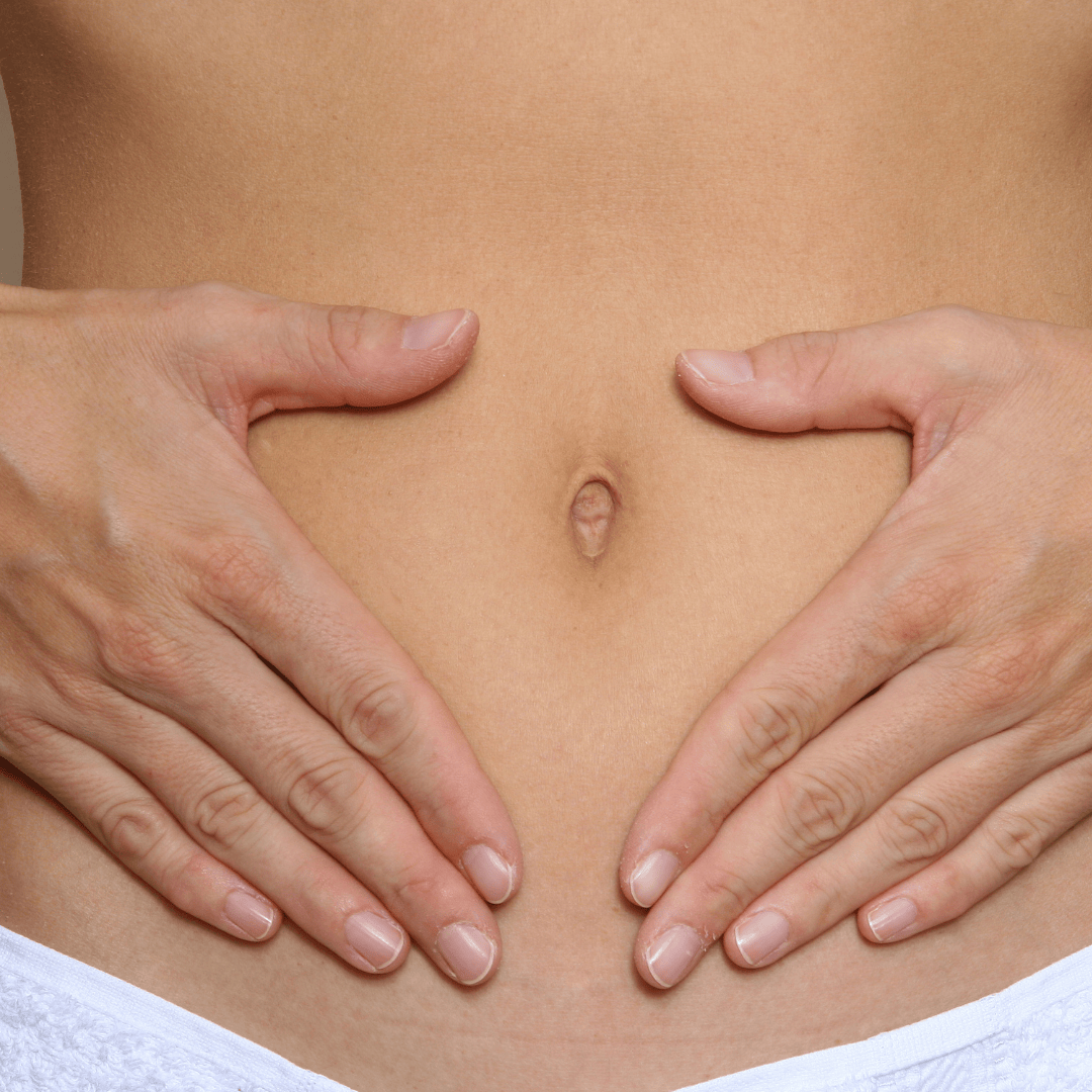 Frau hält Hände auf den Bauch als Symbol für Wohlbefinden in den Wechseljahren