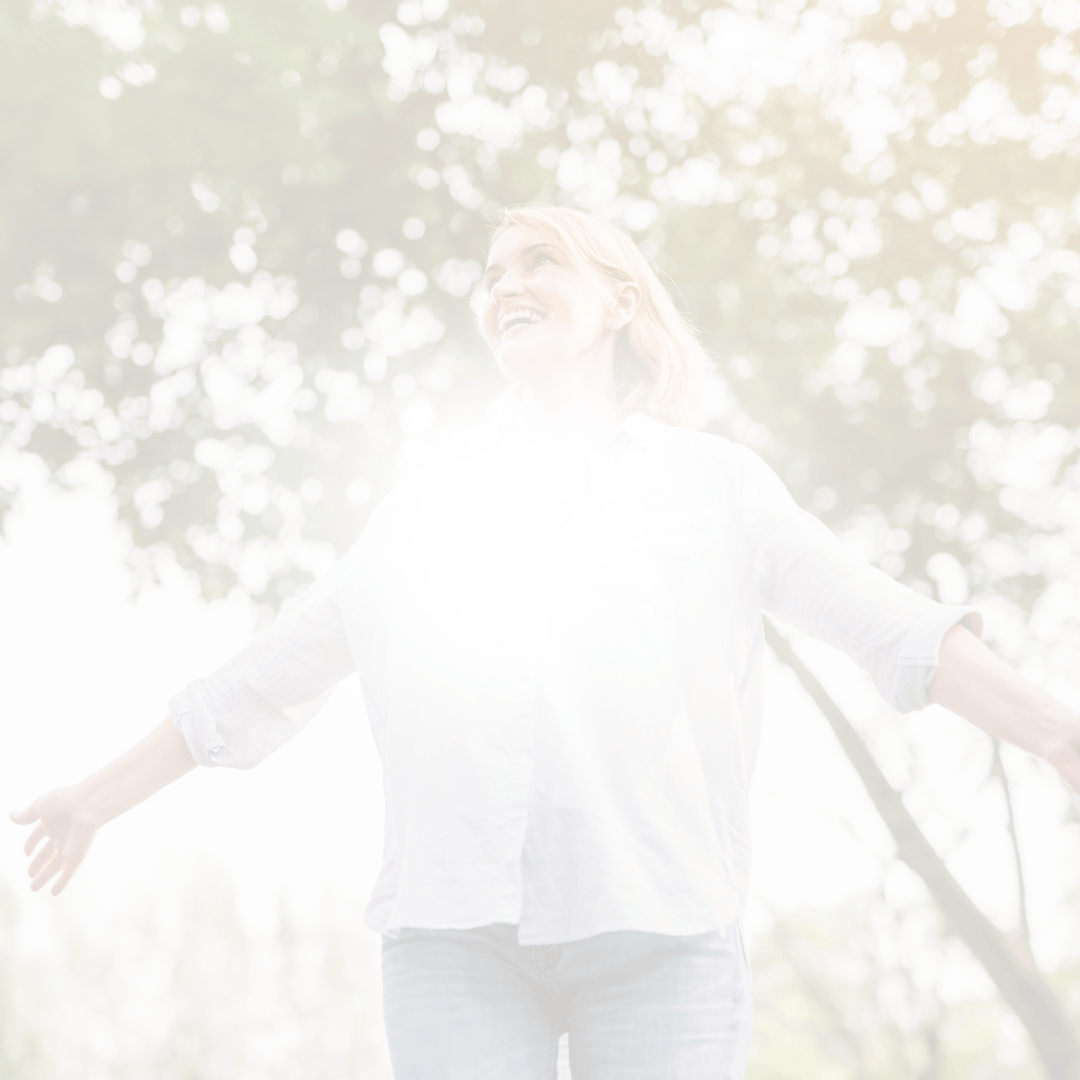 Lächelnde Frau im Wald mit ausgebreiteten Armen als helles, natürliches Stimmungsbild